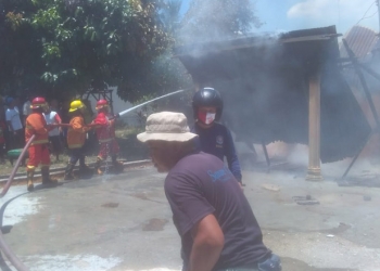 KEBAKARAN - Petugas pemadam berusaha memadamkan kebakaran sebuah rumah milik Nani Saleh (alm) di Desa Pilohayanga Barat, Kecamatan Telaga, Kabupaten Gorontalo, Jumat (26/2/2021). (istimewa)