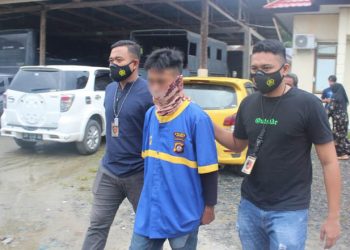 TERSANGKA - Tersangka RB digiring petugas Polres Gorontalo. RB ditetapkan sebagai tersangka dugaan pencabulan adik iparnya yang masih bocah 11 tahun. (putra/gopos)