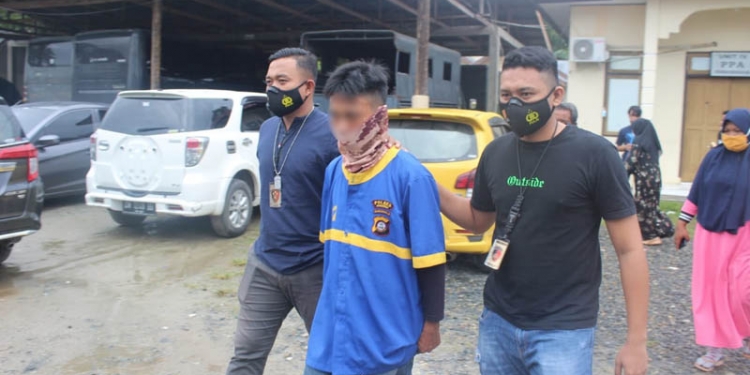 TERSANGKA - Tersangka RB digiring petugas Polres Gorontalo. RB ditetapkan sebagai tersangka dugaan pencabulan adik iparnya yang masih bocah 11 tahun. (putra/gopos)