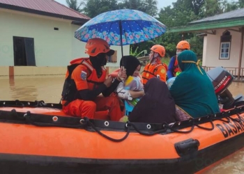 EVAKUASI - Basarnas Gorontalo mengevakuasi dua orang bayi korban banjir di Desa Milango, Kecamatan Tomilito, Kabupaten Gorontalo Utara, Sabtu (13/2/2021). (istimewa)