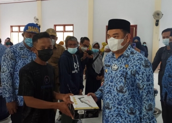 Bupati Bone Bolango Hamim Pou saat menyerahkan bantuan usaha ekonomi produktif untuk masyarakat Desa Kramat. (Foto Lanto/ Prokopim)