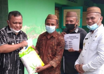 Wakil Bupati Hendra S Hemeto saat memberikan bantuan Kepada Salah seorang warga di Kecamatan Dungaliyo (Putra/Gopos).