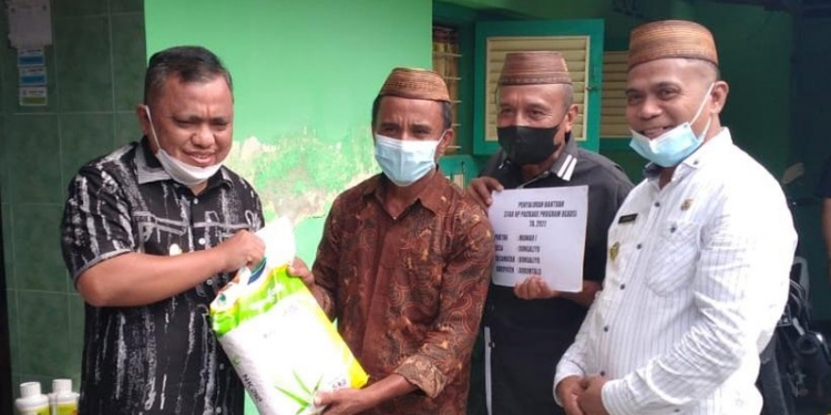 Wakil Bupati Hendra S Hemeto saat memberikan bantuan Kepada Salah seorang warga di Kecamatan Dungaliyo (Putra/Gopos).