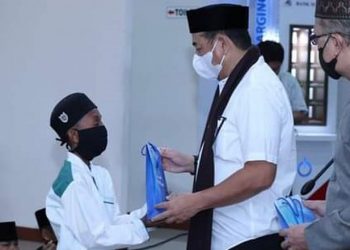 Bupati Bone Bolango Hamim Pou didampingi Kepala Cabang Bank Sulutgo Suwawa Kasmir Abdul Hamid saat menyerahkan bingkisan kepada anak yatim piatu (foto istimewa)
