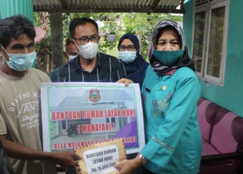 Sekretaris Daerah Kabupaten Gorontalo Hadijah U Tayeb saat memberikan bantuan rumah layak huni Kepada Salah seorang warga di Desa Molowahu Kecamatan Tibawa (Putra Gopos)