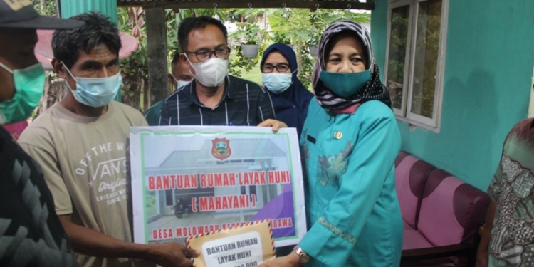 Sekretaris Daerah Kabupaten Gorontalo Hadijah U Tayeb saat memberikan bantuan rumah layak huni Kepada Salah seorang warga di Desa Molowahu Kecamatan Tibawa (Putra Gopos)