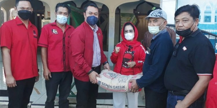 Sekretaris DPD PDI Perjuangan Jatim, Sri Untari saat menyerahkan bantuan material bangunan. (foto : istimewa)