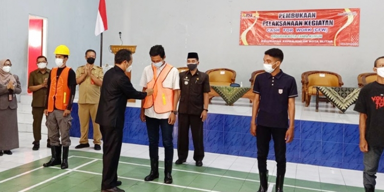 etua DPRD Kota Blitar, Syahrul Alim saat memberikan rompi secara simbolis kepada pekerja. (foto: ma'ruf/gopos)