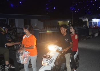 Pembagian masker kepada pengunjung yang melintas di kawasan Tumbilotohe Kampung Sabua, Kelurahan Tenda, Kecamatan Hulonthalangi, Kota Gorontalo, Sabtu (8/5/2021). (putra/gopos)