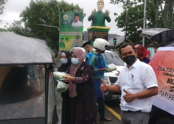 Ketua Ikatan Dokter Indonesia (IDI) Kabupaten Gorontalo, Irawan Huntoyungo beserta jajaran saat membagikan takjil kepada masyarakat yang melintasi di sekitarn patung berdoa Limboto. (Putra Gopos)