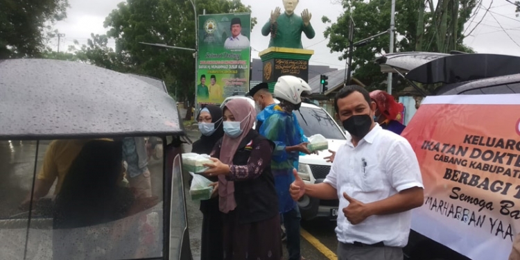 Ketua Ikatan Dokter Indonesia (IDI) Kabupaten Gorontalo, Irawan Huntoyungo beserta jajaran saat membagikan takjil kepada masyarakat yang melintasi di sekitarn patung berdoa Limboto. (Putra Gopos)