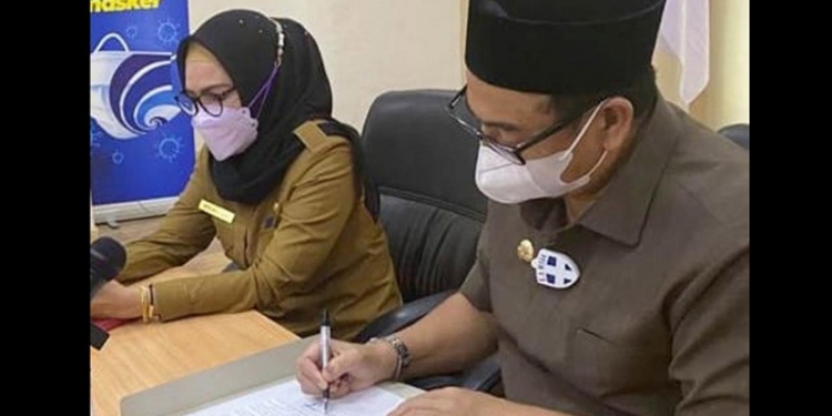 Bupati Hamim Pou didampingi Wakil Bupati Merlan S. Uloli menandatangani persetujuan pembayaran THR maupun gaji ke-14 bagi seluruh ASN di lingkungan Pemkab Bone Bolango, di ruang rapat Bupati Bone Bolango, Senin (3/5/2021). (foto Istimewa)