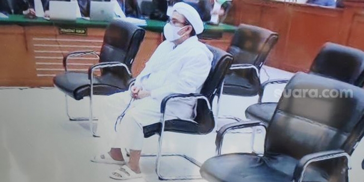 Habib Rizieq Shihab mengikuti pembacaan putusan kasus pelanggaran Prokes Megamendung di Pengadilan Negeri Jakarta Timur, Kamis (27/5/2021). (suara.com)