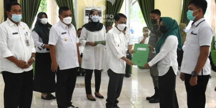 Bupati Gorontalo Nelson Pomalingo saat melakukan penyerahan Surat Keputusan (SK) kepada salah satu Tenaga Kontrak Tahap III. (Humas Kominfo Kabupaten Gorontalo)