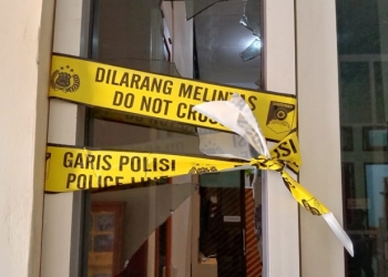 Garis polisi dipasang tepat di kaca yang pecah akibat insiden di gedung DPRD Pohuwato, Jumat (7/4/2021).