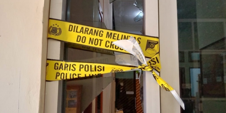 Garis polisi dipasang tepat di kaca yang pecah akibat insiden di gedung DPRD Pohuwato, Jumat (7/4/2021).