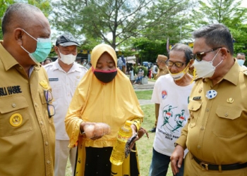 Gubernur Gorontalo Rusli Habibie bersama Wali Kota Gorontalo Marten Taha saat menyapa salah seorang masyarakat yang membeli di pasar murah yang kembali dilaksanakan oleh Pemprov Gorontalo khusus untuk maysarakat di Kota Tengah, Kota Gorontalo, Senin (10/5/2021). (Foto – Salman/Humas Pemprov)