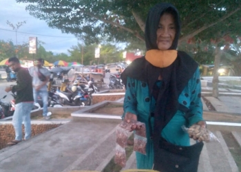 Isna Mohamad, salah seorang penjual makanan ringan di kawasan pohon cinta Pohuwato. (ramlan/gopos)