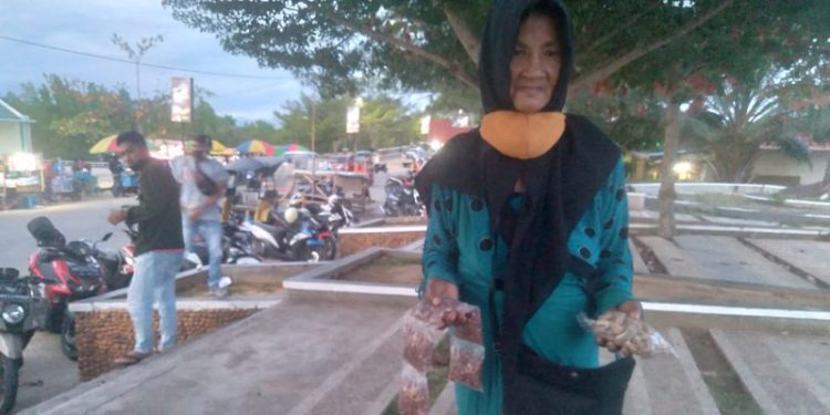 Isna Mohamad, salah seorang penjual makanan ringan di kawasan pohon cinta Pohuwato. (ramlan/gopos)