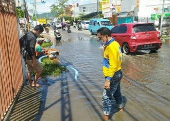 PERBAIKAN JALAN - Petugas Dinas PUPR Kota Gorontalo melakukan penyedotan genangan air di Jalan HB.  Jassin Kota Gorontalo, Ahad (23/5/2021). Foto (Diskominfo Kota Gorontalo)