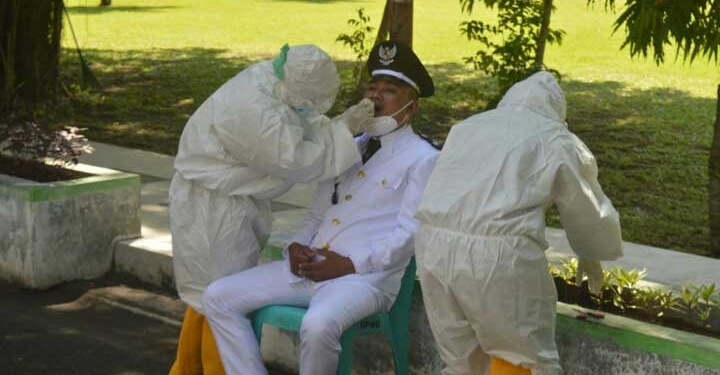 Pemeriksaan Swab Antigen kepada salah satu kepala desa, sebelum pelantikan dimulai. (Foto: Putra/Gopos)