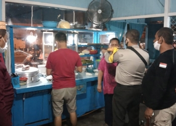 Petugas Polsek Dungingi memberikan masker kepada warga dalam pemantauan protokol kesehatan di rumah makan dan pusat keramaian warga, Sabtu (13/6/2021). (Dok. Humas Polda Gorontalo)