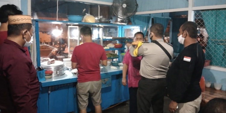 Petugas Polsek Dungingi memberikan masker kepada warga dalam pemantauan protokol kesehatan di rumah makan dan pusat keramaian warga, Sabtu (13/6/2021). (Dok. Humas Polda Gorontalo)