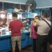Petugas Polsek Dungingi memberikan masker kepada warga dalam pemantauan protokol kesehatan di rumah makan dan pusat keramaian warga, Sabtu (13/6/2021). (Dok. Humas Polda Gorontalo)