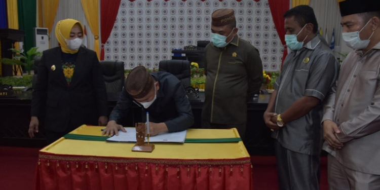 Bupati Pohuwato, Saipul Mbuinga dan Ketua DPRD Pohuwato, Nasir Giasi, saat melakukan penandatanganan nota kesepakatan RPJMD tahun 2021-2026 di Aula DPRD Pohuwato, Senin (7/6/2021). (foto/ramlan/gopos).