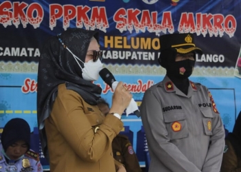 Wakil Bupati Bone Bolango, Merlan S. Uloli saat menghimbau masyarakat menerapkan protokol kesehatan dan melakukan vaksinasi di Posko PPKM Desa Helumo Kecamatan Suwawa (foto Irul/Kominfo)