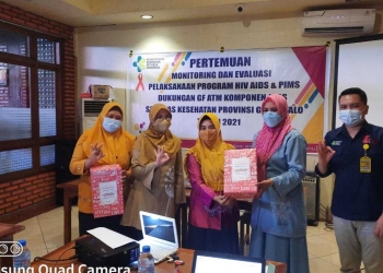 Kepala Dinas Kesehatan Provinsi Gorontalo, dr. Yana Yanti Suleman, sedang menyerahkan hadiah kepada petugas Puskesmas Dumbo Raya. Sebagai pemenang kategori layanan HIV dengan cakupan tes populasi kunci terbanyak, Rabu (3/6/2021). (Foto: Tim Infokom Dinkes)