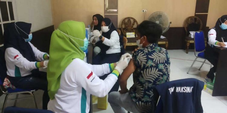 Nandi Salah seorang warga asal kelurahan Hutuo saat divaksinasi Covid-19, di Kantor Camat Limboto, Selasa (29/06/2021). (Foto: Woyo/Gopos)
