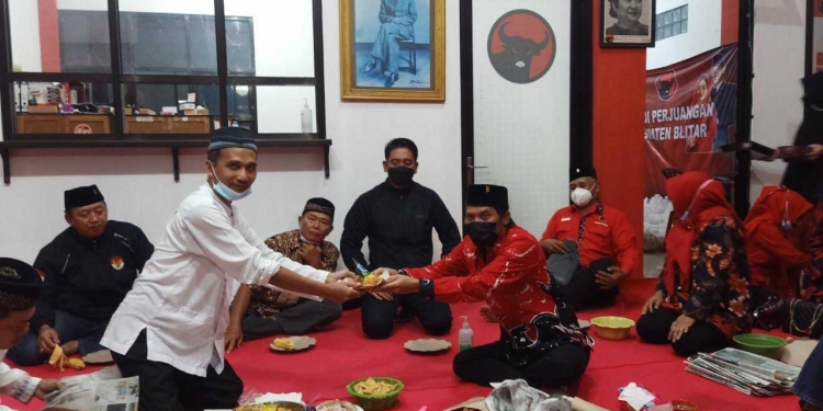 Penyerahan potongan tumpeng kepada Sekretaris DPC PDI Perjuangan Kabupaten Blitar, Suwito, sesaat setelah Do'a Bersama Haul Bung Karno, di Kantor DPC PDI Perjuangan Kabupaten Blitar, Minggu (20/6/2021). (Foto: Ma'ruf/Gopos)