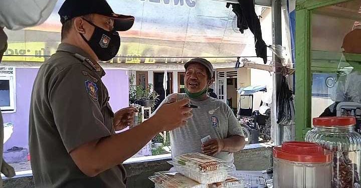 Petugas SATPOL PP sedang menjelaskan peraturan daerah tentang mendirikan bangunan yang dilanggar oleh pedagang. (Foto: Aldy/gopos)