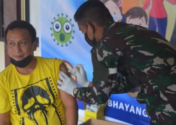 Cristian (39) masyarakat asal Kelurahan Dutulanaa Kecamatan Limboto saat disuntikkan vaksin. (Foto: Putra/ Gopos)