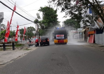 Petugas Kepolisian saat melakukan penyemprotan desinfektan di sepanjang jalan. Foto istimewa