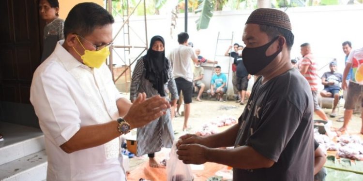 Wali Kota Gorontalo, Marten Taha saat membagikan daging qurban kepada masyarakat. Foto (Diskominfo Kota Gorontalo)