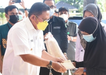 Wali Kota Gorontalo, Marten Taha saat menyerahkan bantuan kepada salah satu KPM Kota Gorontalo. Foto (Diskominfo Kota Goronalo)