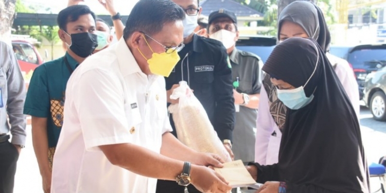 Wali Kota Gorontalo, Marten Taha saat menyerahkan bantuan kepada salah satu KPM Kota Gorontalo. Foto (Diskominfo Kota Goronalo)
