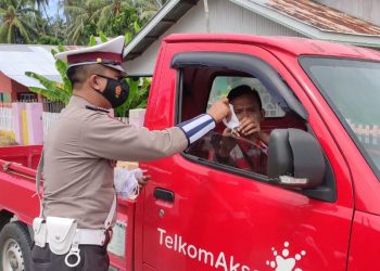 Salah satu anggota kepolisian di Satuan Lalu Lintas Polres Bone Bolango saat melakukan himbauan penggunaan masker kepada masyarakat. (Foto Istimewa)
