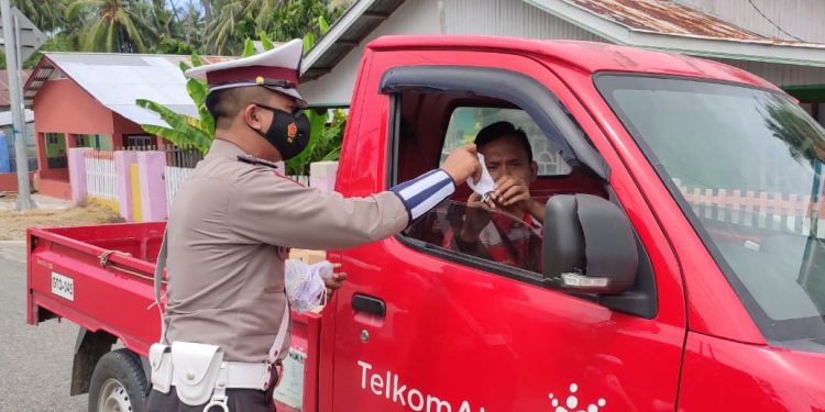 Salah satu anggota kepolisian di Satuan Lalu Lintas Polres Bone Bolango saat melakukan himbauan penggunaan masker kepada masyarakat. (Foto Istimewa)
