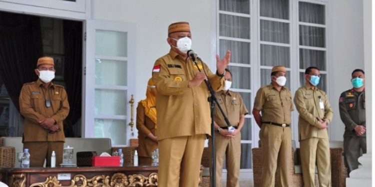 Gubernur Gorontalo Rusli Habibie didampingi Sekda dan sejumlah pimpinan OPD saat memberi keterangan pers di Halaman Rumah Jabatan, Senin (12/7/2021). Rusli meminta dukungan masyarakat untuk taat protokol kesehatan untuk mencegah lonjakan pasien covid-19 di daerah. (Foto:  Istimewa).
