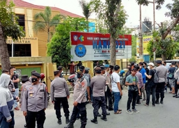 Pihak Polres Gorontalo Kota sedang membubarkan massa aksi yang tengah berorasi di depan kantor Dinas Kesehatan Provinsi Gorontalo, Jum'at (23/7/2021) (Foto: Sari/gopos)