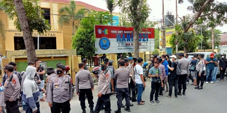 Pihak Polres Gorontalo Kota sedang membubarkan massa aksi yang tengah berorasi di depan kantor Dinas Kesehatan Provinsi Gorontalo, Jum'at (23/7/2021) (Foto: Sari/gopos)