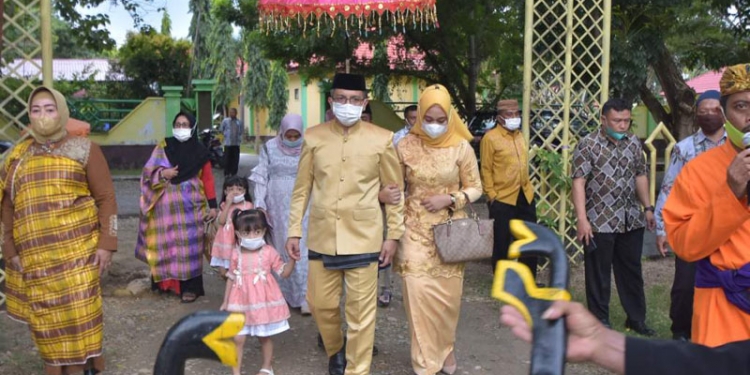 Pjs Sekda Pohuwato, Zukri Surotinojo, bersama Ketua DPW Pohuwato, Ny. Neng Surotinojo Niode, menjalani prosesi adat mopotilolo, Jumat (9/7/2021).