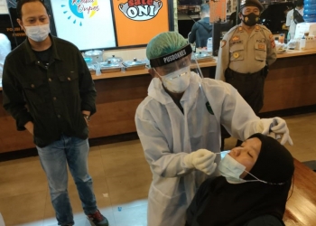 Petugas Dokkes Polres Gorontalo Kota melakukan pengambilan sampel untuk uji rapid antigen sejumlah pengunjung dan karyawan kafe di Kota Gorontalo, Sabtu (3/7/2021).  (Humas Polda Gorontalo)