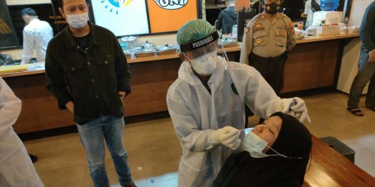 Petugas Dokkes Polres Gorontalo Kota melakukan pengambilan sampel untuk uji rapid antigen sejumlah pengunjung dan karyawan kafe di Kota Gorontalo, Sabtu (3/7/2021).  (Humas Polda Gorontalo)