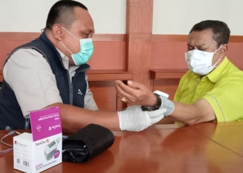 Ketua DPRD Provinsi Gorontalo, Paris Yusuf, yang juga Sekretaris DPD I Golkar Gorontalo menjalani pemeriksaan kesehatan untuk penyuntikan vaksin. (sari/gopos)