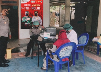 Anggota Polres Gorontalo Kota sedang melakukan pendataan terhadap warga yang akan divaksin (Foto : Humas)