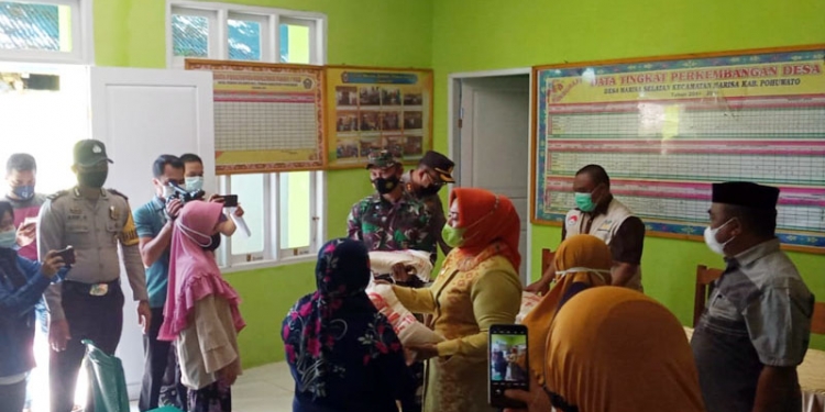 Wakil Bupati Pohuwato, Suharsi Igirisa, secara simbolis menyerahkan bantuan beras bagi PKH dan BST di Pohuwato, Kamis (29/7/2021).(Kominfo Pohuwato)